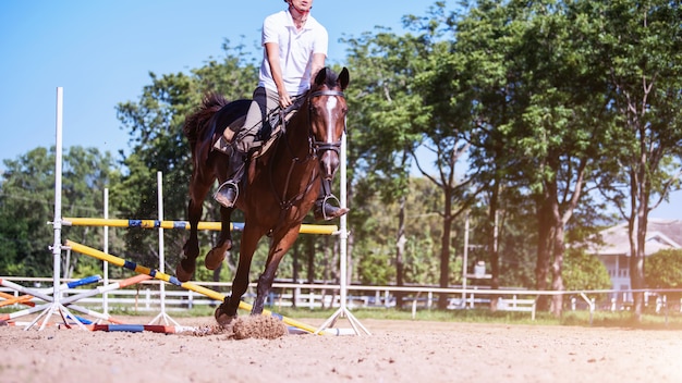 Giovane sportivo che intraprende il suo corso sulla concorrenza di salto del cavallo di manifestazione