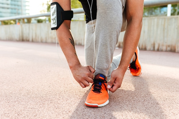 Young sportsman ties his sport shoe