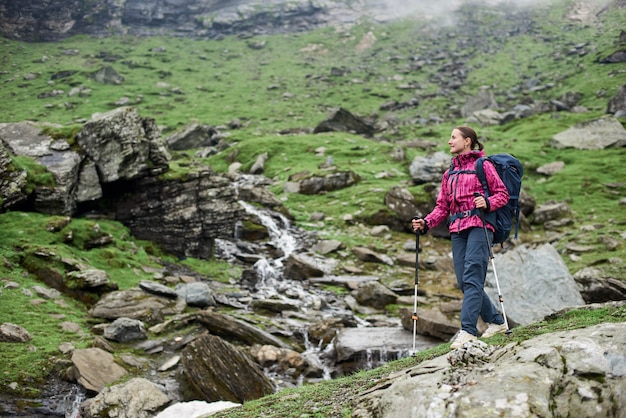 Young sportswoman hiking in the mountains with a backpack