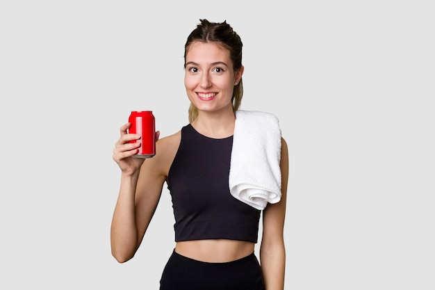 Young sportswoman holding sugary drink with a look of disapproval