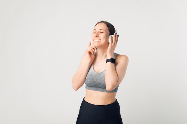 Young sportswoman is enjoying the music she is listening in her earphones.