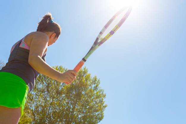 Young sportswoman playing on tennis court