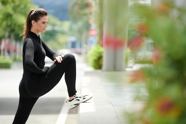 Photo young sportswoman stretching legs