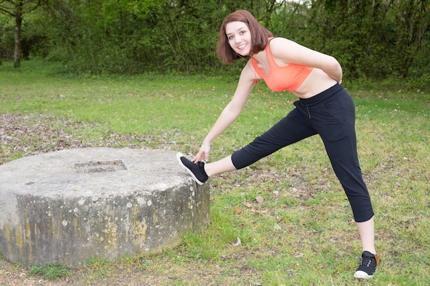 Young sportswoman stretching and preparing to run