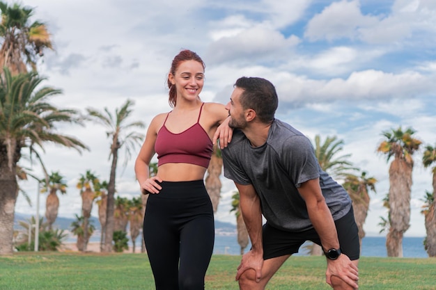 Photo a young sporty couple smiling and having a break in a success workout outdoors