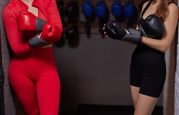 A young sporty girl putting on boxing gloves close up