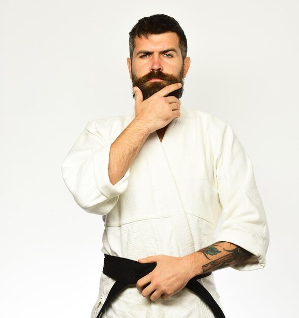 Young sporty man in kimono on white background