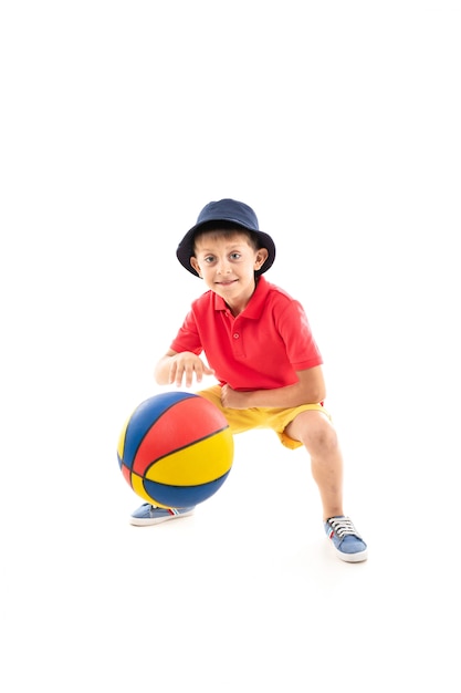 young sporty smiling child throws a basketball ball on white