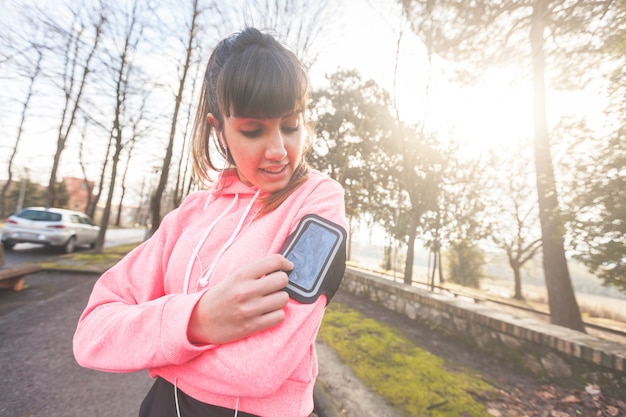 写真 スポーティな女性のトレーニング中にスマートフォンをチェック