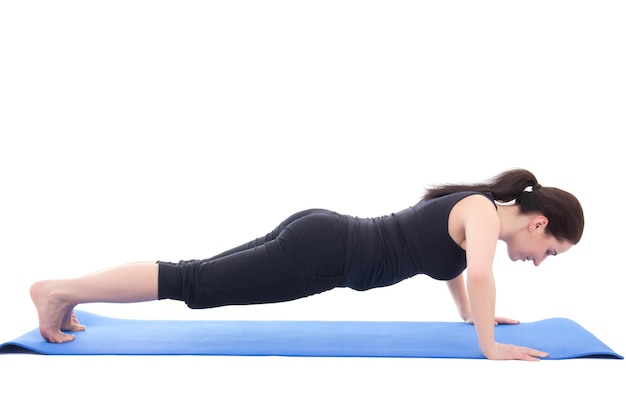 Young sporty woman doing push up exercise isolated on white background