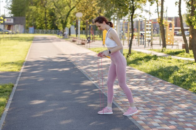 スポーツアウトドアフィットネスエクササイズをしている若いスポーティな女性