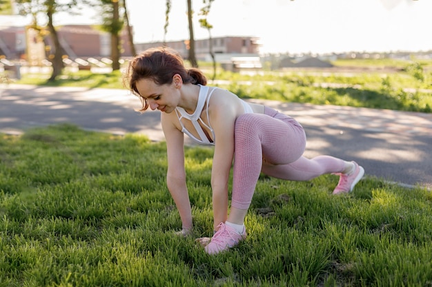 Foto giovane donna sportiva che fa sport all'aperto esercizi di fitness