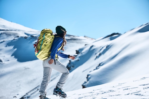 雪山をハイキングする若いスポーティな女性