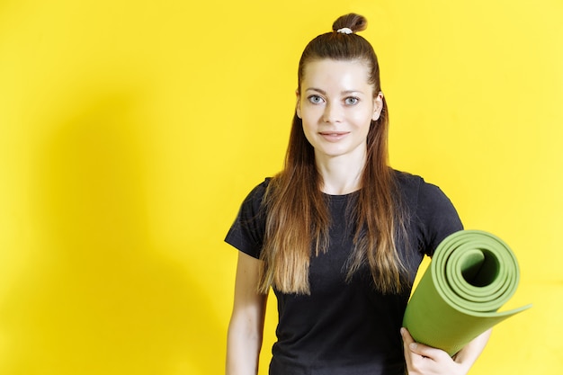 Young sporty woman holding a Mat