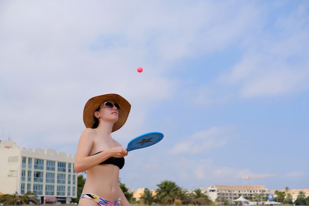 Giovane donna sportiva che gioca beach tennis della sfera favola