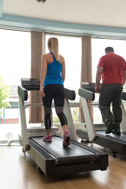 Foto giovane donna sportiva correre sulla macchina nel centro della palestra