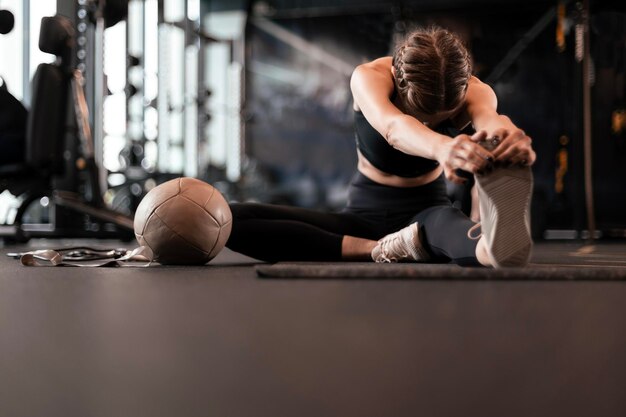 Young sporty woman stretching at the gym