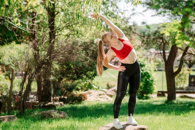 Young sporty woman warming up outdoors un the park