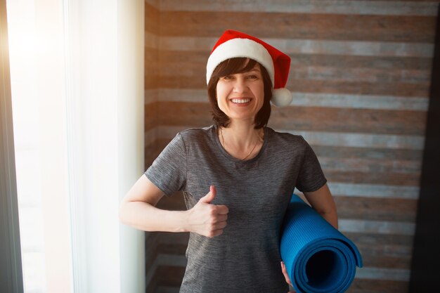 Young sporty woman with Santa's hat