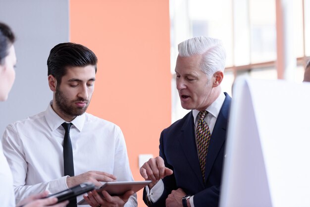 young startup businessman making presentation of project to senior investior, group of business people taking notes and make plans on white  flip board and tablet computer