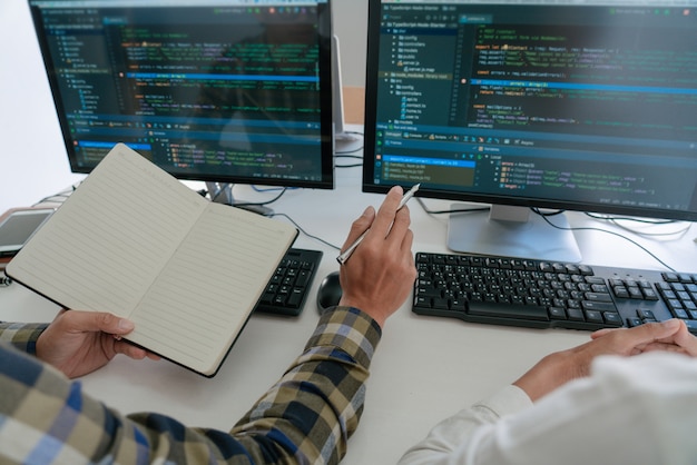 Young startup Programmers Sitting At Desks Working On Computers screen for Developing programming and coding to find solution to problem on New Application.