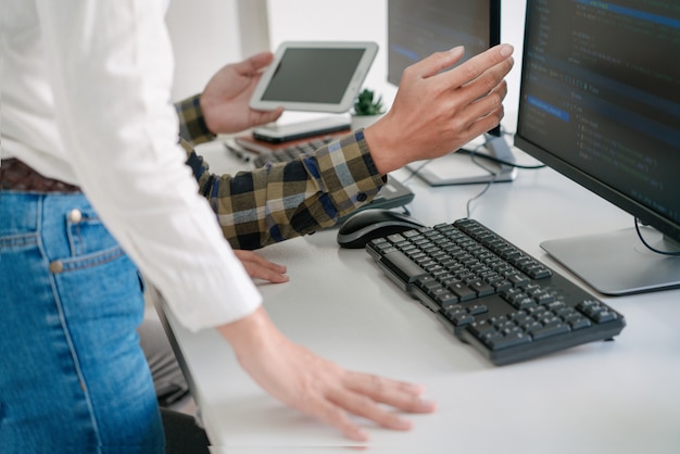 Young startup Programmers Sitting At Desks Working On Computers screen for Developing programming and coding to find solution to problem on New Application.