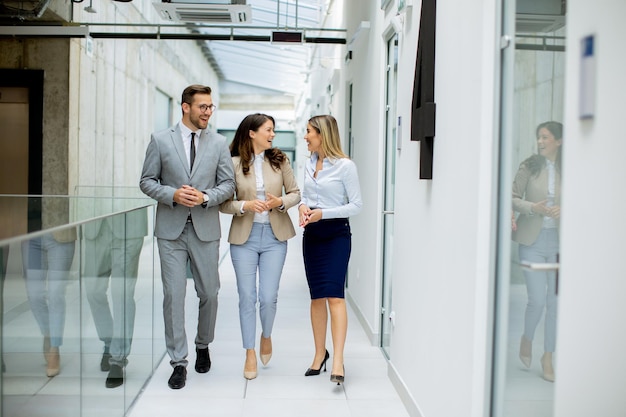 Foto il giovane team di startup discute mentre cammina nel corridoio dell'ufficio