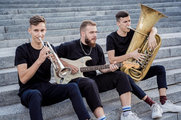 Young street music band play a lot of musical instruments