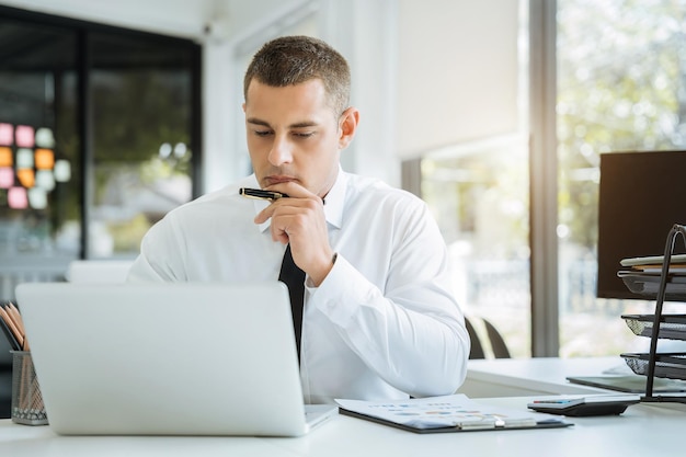 Young stressed Asian businessman working in the office Businessman thinking too much work concept in the office