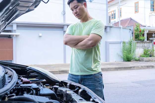 Young stressed Asian man having trouble with his broken car