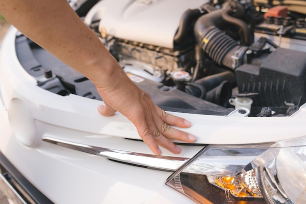 Young stressed man having trouble with his broken car looking in frustration at failed engine