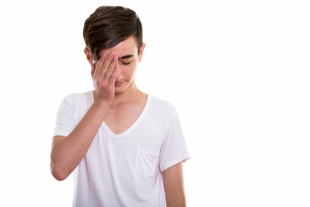 young stressed Persian teenage boy covering his face