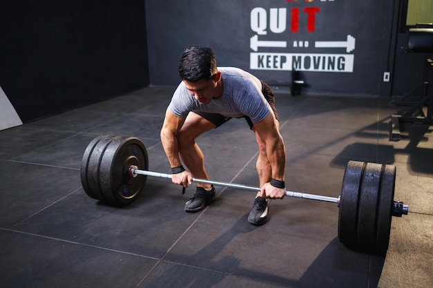 Young strong man doing deadlift exercise for bodybuilder\'s\
abdominal muscles in gym