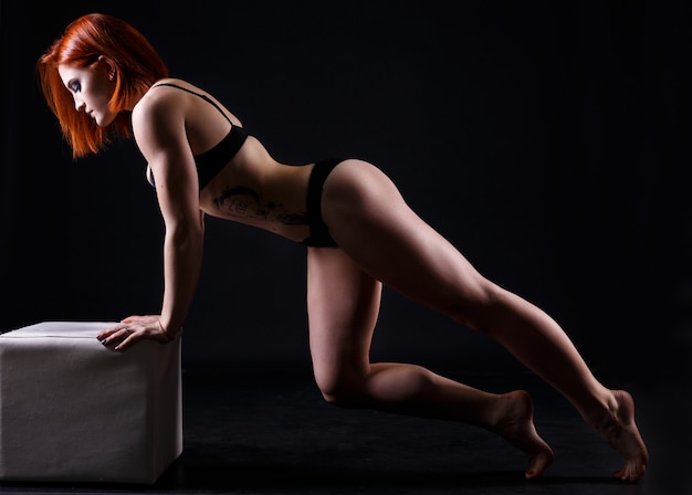 Молодая сильная сексуальная женщина, показывая ее мышцы.