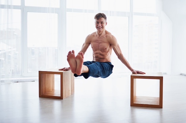 Photo young strong shirtless man practices yoga at the yoga studio