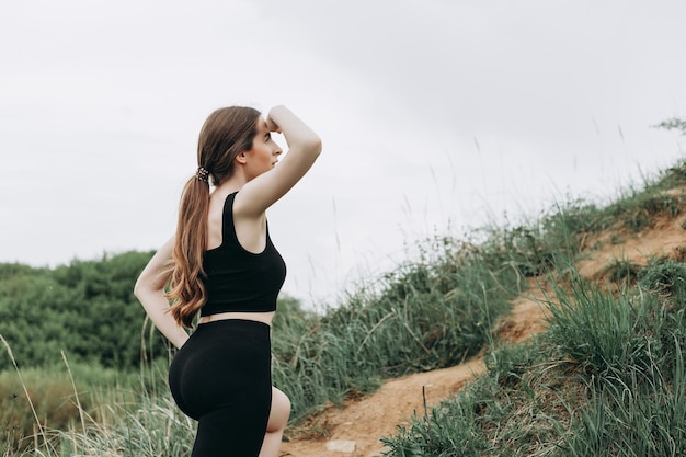 Young strong woman climbs to top of cliff Overcoming obstacles and courage Ambitious climber climb