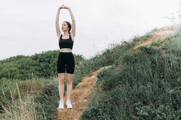 Young strong woman climbs to top of cliff overcoming obstacles\
and courage ambitious climber climb