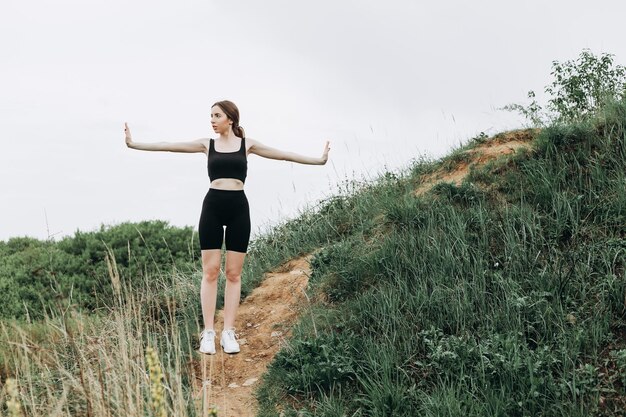 Young strong woman climbs to top of cliff overcoming obstacles
and courage ambitious climber climb