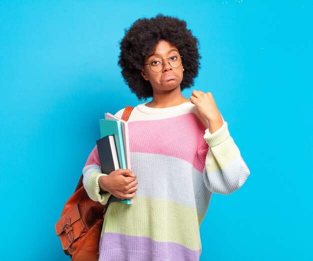 Young student afro woman looking arrogant