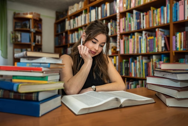 Young student after graduation comes to the library to learn new knowledge