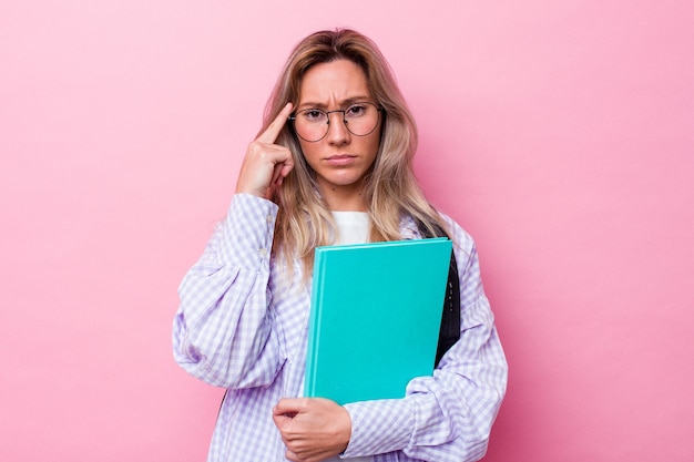 Young student australian woman isolated on pink background pointing temple with finger, thinking, focused on a task.