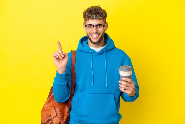 Young student blonde man isolated on yellow background showing and lifting a finger in sign of the best