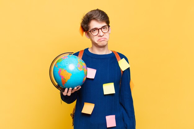 Giovane studente che si sente triste e piagnucoloso con uno sguardo infelice, piange con un atteggiamento negativo e frustrato