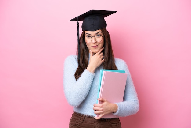 Young student Brazilian woman wearing graduated hat isolated on pink background thinking