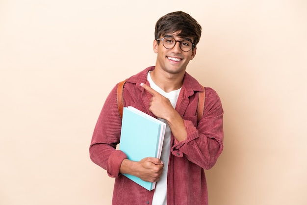 Young student caucasian man isolated on ocher background\
pointing to the side to present a product