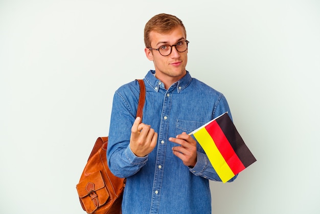 Young student caucasian man studying german isolated on white pointing with finger at you as if inviting come closer.