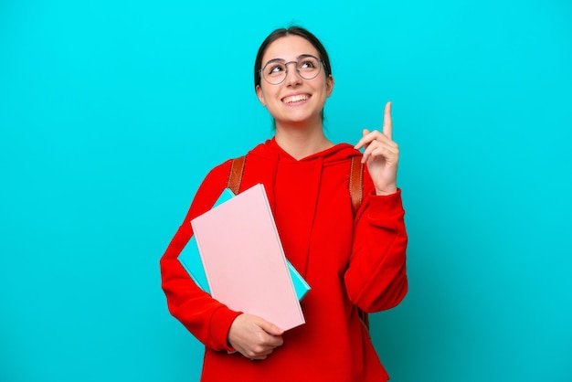 Donna caucasica giovane studente isolata su sfondo blu che indica una grande idea