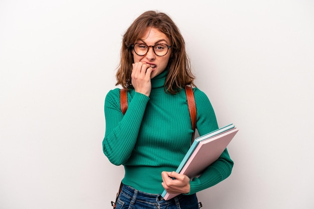 Young student caucasian woman isolated on white background biting fingernails nervous and very anxious