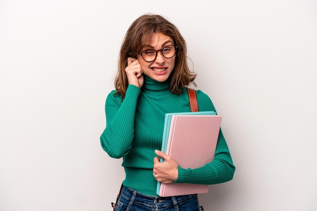 Young student caucasian woman isolated on white background covering ears with hands