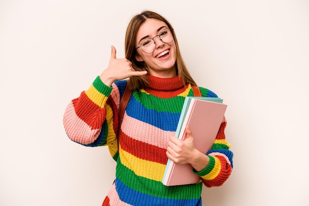 指で携帯電話の呼び出しジェスチャーを示す白い背景で隔離の若い学生白人女性